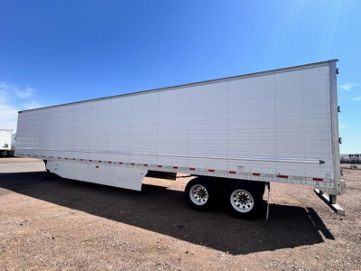 Great Dane reefer trailer side view showing tandem axles, white aluminum panels, and reflective striping.