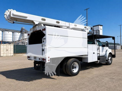Truck rear/side view showing bucket lift and utility body on a Ford F-750 XL SD, white with hydraulic boom extended, rear view highlights buckets and compartments.