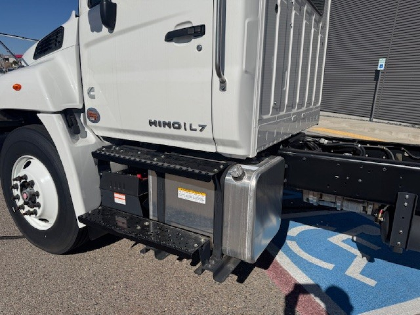 Truck cab and chassis showing HINO L7 badge with toolbox and steps attached under cab