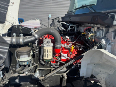 Hino L7 engine bay showing Red engine block and air intake, hoses, and assorted components.