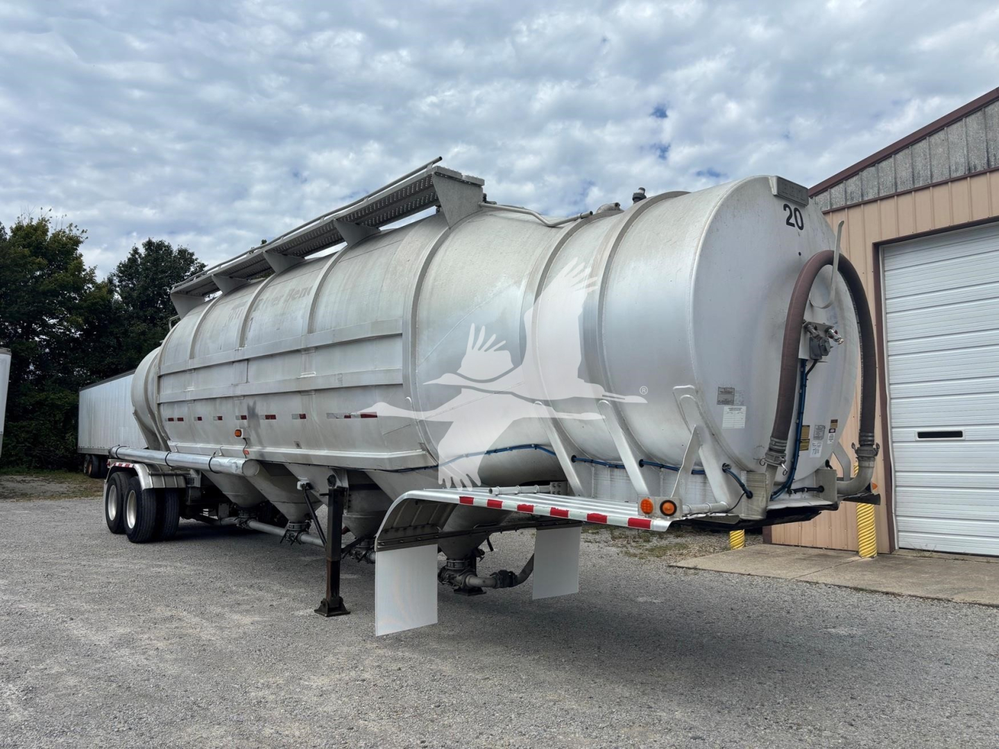 Trailer showing hull with rounded cylindrical tank and rear hoist for Heil 1625 Super Flo pneumatic-dry bulk trailer, silver/metallic finish, number 20.