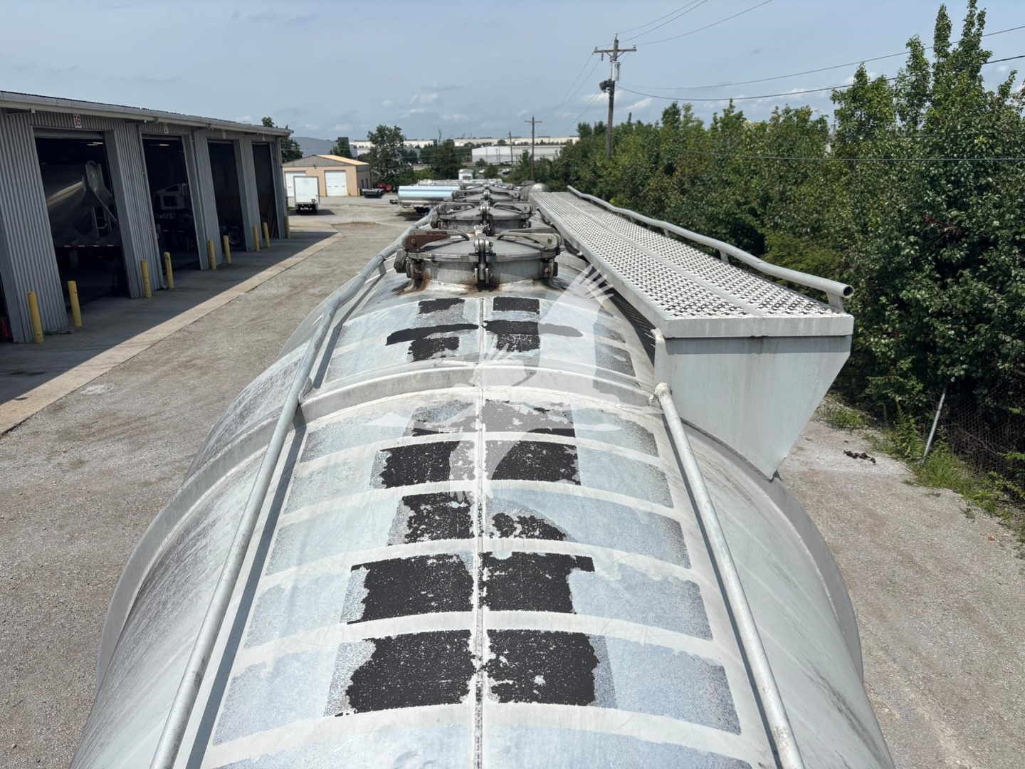 Top view of a Heil 1625 Super Flo pneumatic trailer showing riveted metal cylindrical tank with access hatches and ladder/rack along the top, used condition.