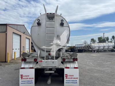 Rear view of a 2000 Heil 1625 Super Flo pneumatic trailer showing the tanker barrel, tail lights, ladder, and rear bumper with State Trailer Sales logos on the left and right.