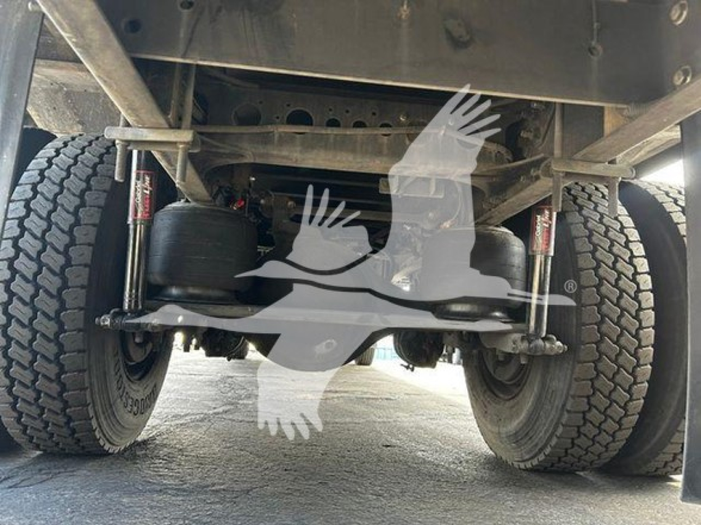 Underfront view of a Hino 268a truck showing rear suspension with air springs and dual tires.