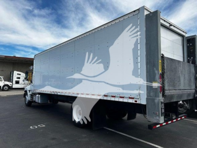 Box truck trailer with light blue graphic art depicting birds, rear and side view showing doors, reflective tape, and white wheels.