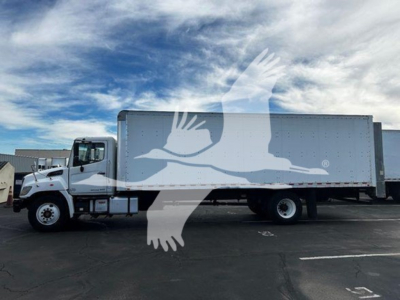 Truck in a parking lot with a large box body; watermark of a flying bird across the side. Side text not clearly legible.