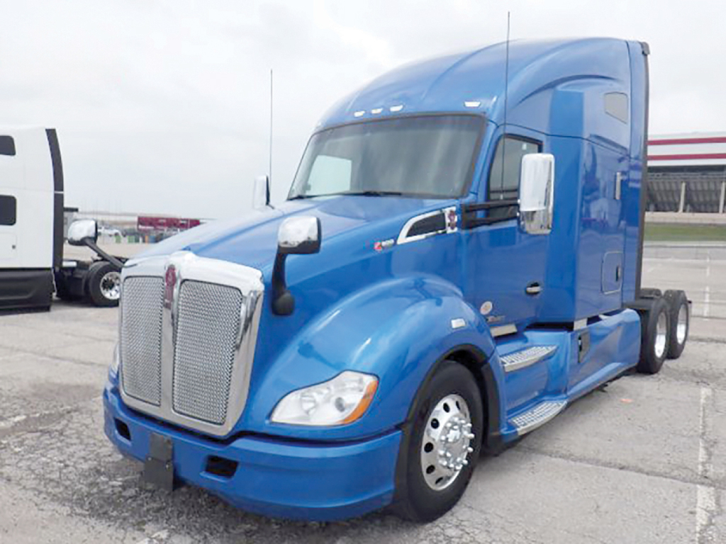 Kenworth T680 blue sleeper tractor from front-left-side view showing chrome grille, headlights, side mirrors, and blue body panels.