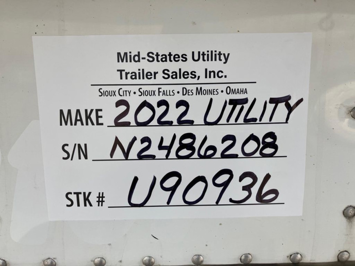 Sign on a trailer showing Make 2022 Utility, S/N N2486208, Stock U90936 with MT signage. Handwritten: MAKE 2022 UTILITY, S/N N2486208, S/TK # U90936.