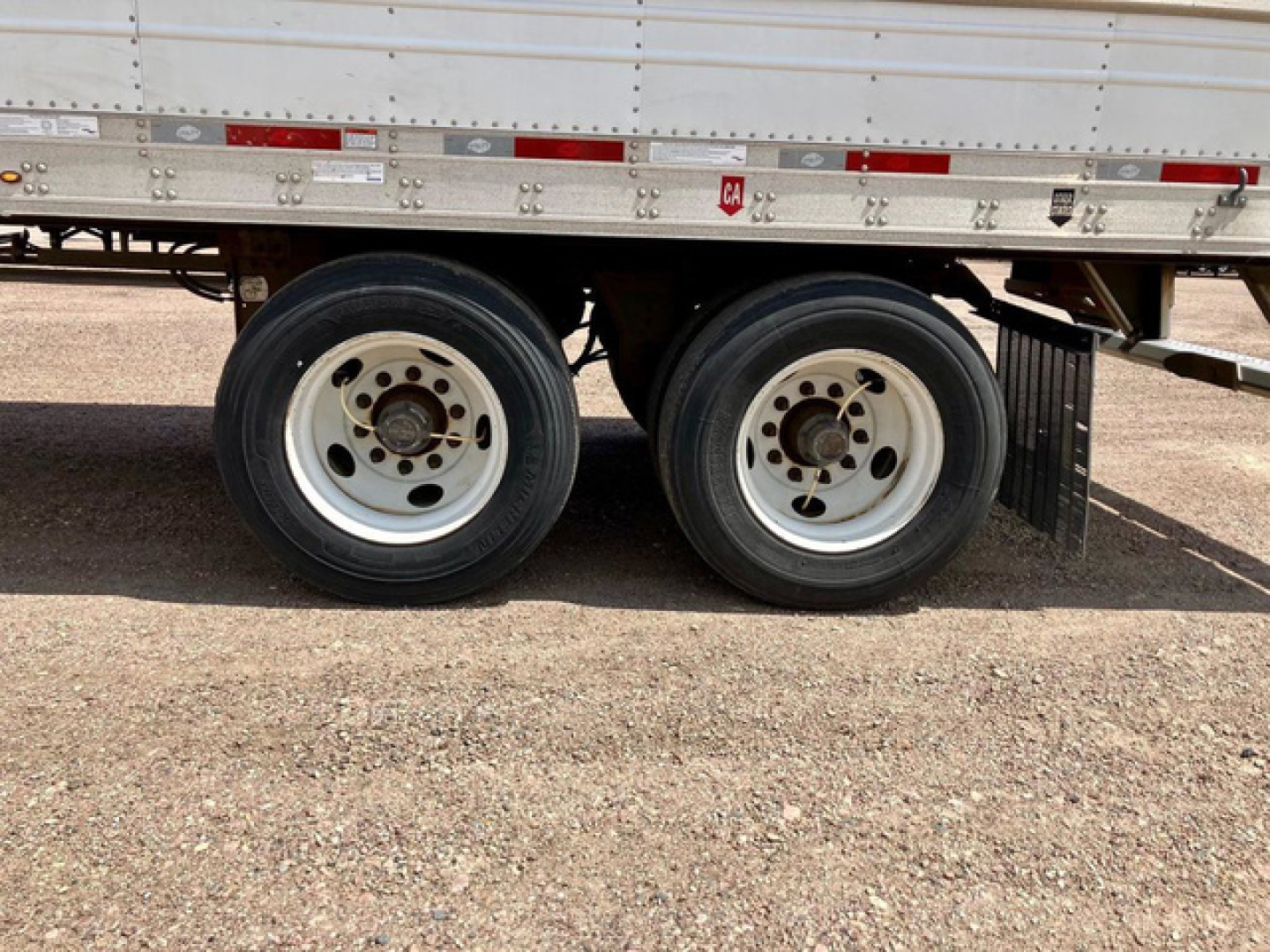 Trailer dual rear wheels of a 2022 Utility reefer trailer showing two white rims and black tires under a silver refrigerated box.