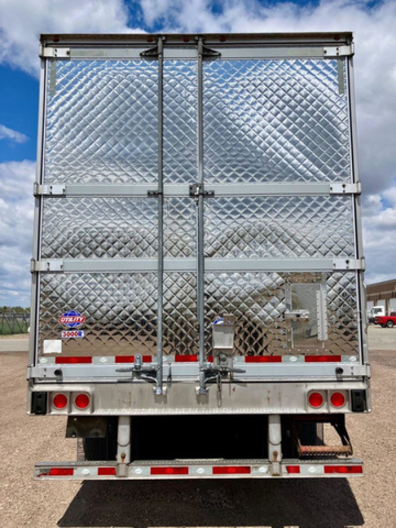 Back of a 2022 Utility refrigerated trailer with diamond-plate aluminum doors, rear doors closed, bumper, and taillights.