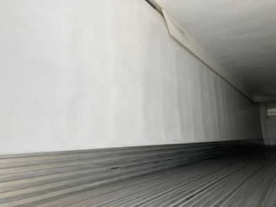 Trailer interior cargo area with ribbed metal floor and white side walls, utility reefer trailer interior view.