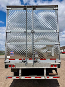 Back of a 2022 Utility refrigerated trailer with diamond-plate aluminum doors, rear doors closed, bumper, and taillights.
