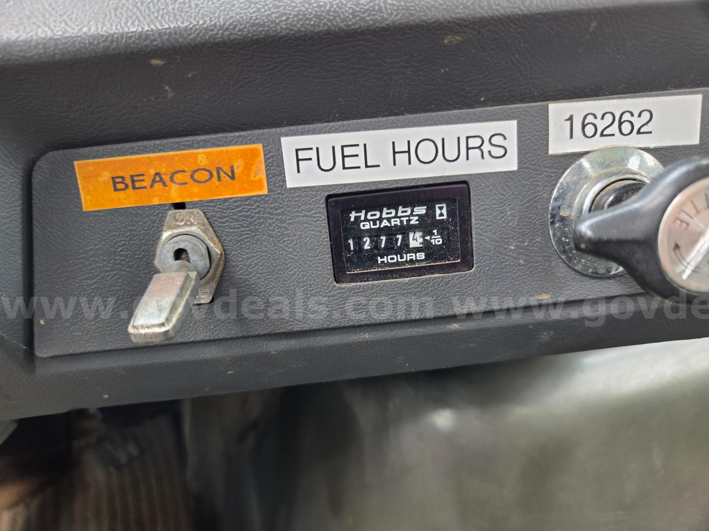 Ford LN8000F dashboard area showing beacon label, fuel hours gauge, and hour meter with 127, 1 2 7 4 6 hours, VIN label 16262, and a key switch.