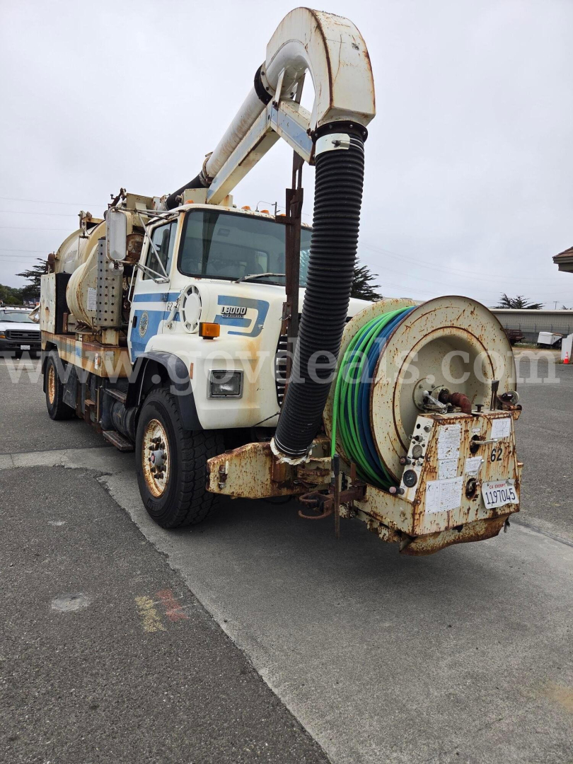 Ford LN8000 vacuum truck with reel, vacuum hose, and multiple tanks, front cab visible