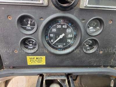 Dashboard of a Ford LN8000F showing gauges including fuel, temp, volts, oil, and a central speedometer with odometer. A yellow seat belts sticker is present.
