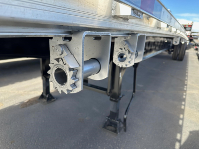 Manac 53' combo flatbed trailer showing undercarriage with landing gear and support brackets, metallic components, and wheel-well details.