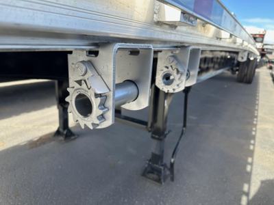 Manac Legend flatbed trailer undercarriage showing landing legs and mounting hardware.