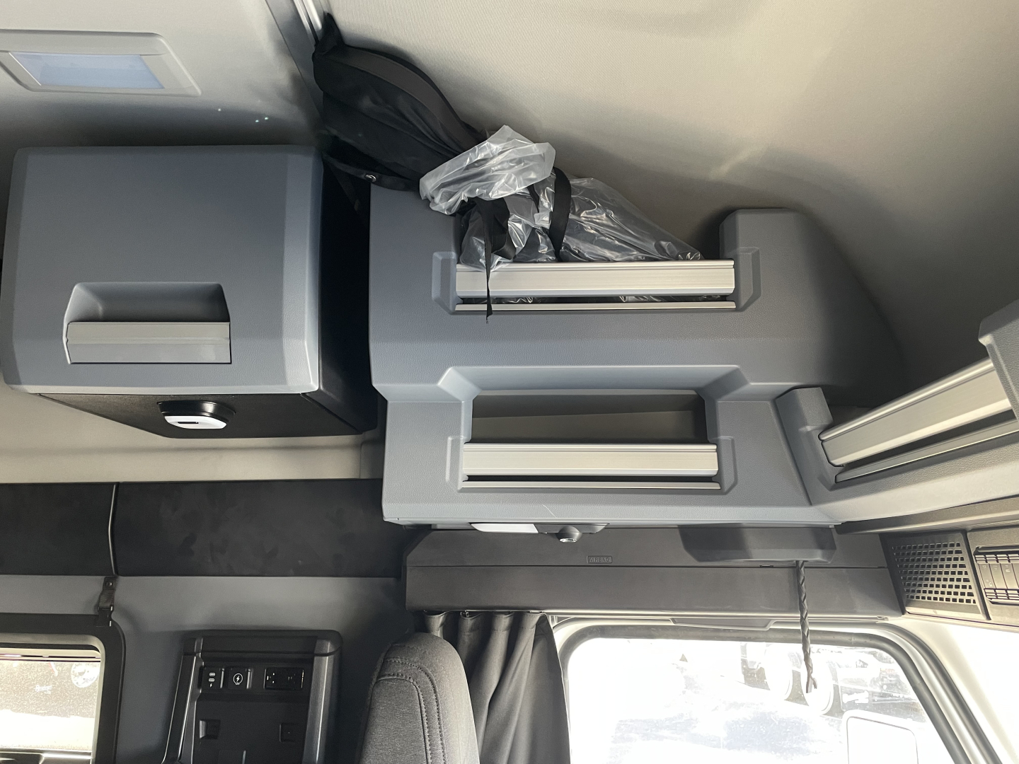 Interior overhead console area of a Mack PR64T64 sleeper cab showing storage compartments and controls.