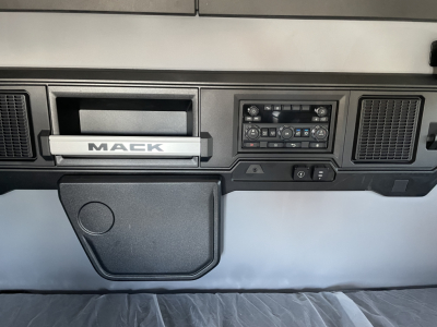 Mack PR64T64 dash area showing infotainment controls and storage compartment.