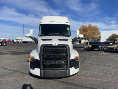 Front view of a white 2026 Mack PR64T64 conventional sleeper truck in a dealership lot, with large grille and headlights visible