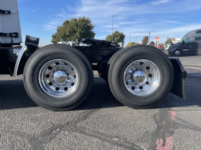 Twin rear wheels of a Mack PR64T64 tractor showing chrome rims and tires, undercarriage components visible between the axles.
