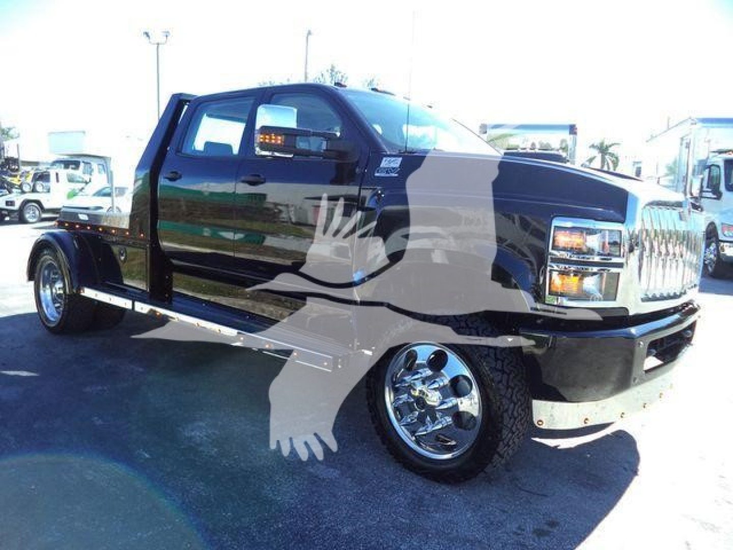 Truck cab and bed of a black 2023 International Cv/crew cab truck showing chrome wheels and dual rear wheels.