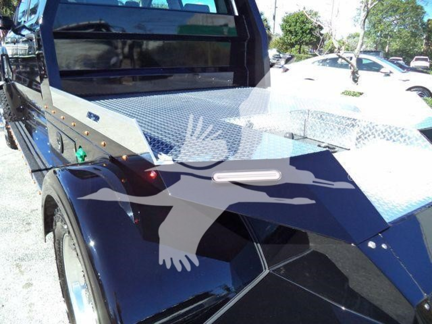 Truck bed of a 2023 International CV with diamond plate metalwork and black body panels, side view showing wheel and cargo area.