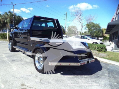 Front-left exterior of a 2023 International CV truck in a parking lot with custom flatbed and chrome wheels.