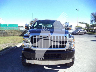 Truck front view of a 2023 International Cv with large chrome grille and heavy bumper in a dealership lot.