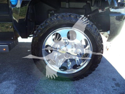 Wheel and tire on a pickup truck with shiny chrome rim and rugged tire. Partial truck bed and fender visible.