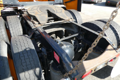 Volvo truck chassis showing rear axles and fifth-wheel with chain, undercarriage with suspension and drive components visible.