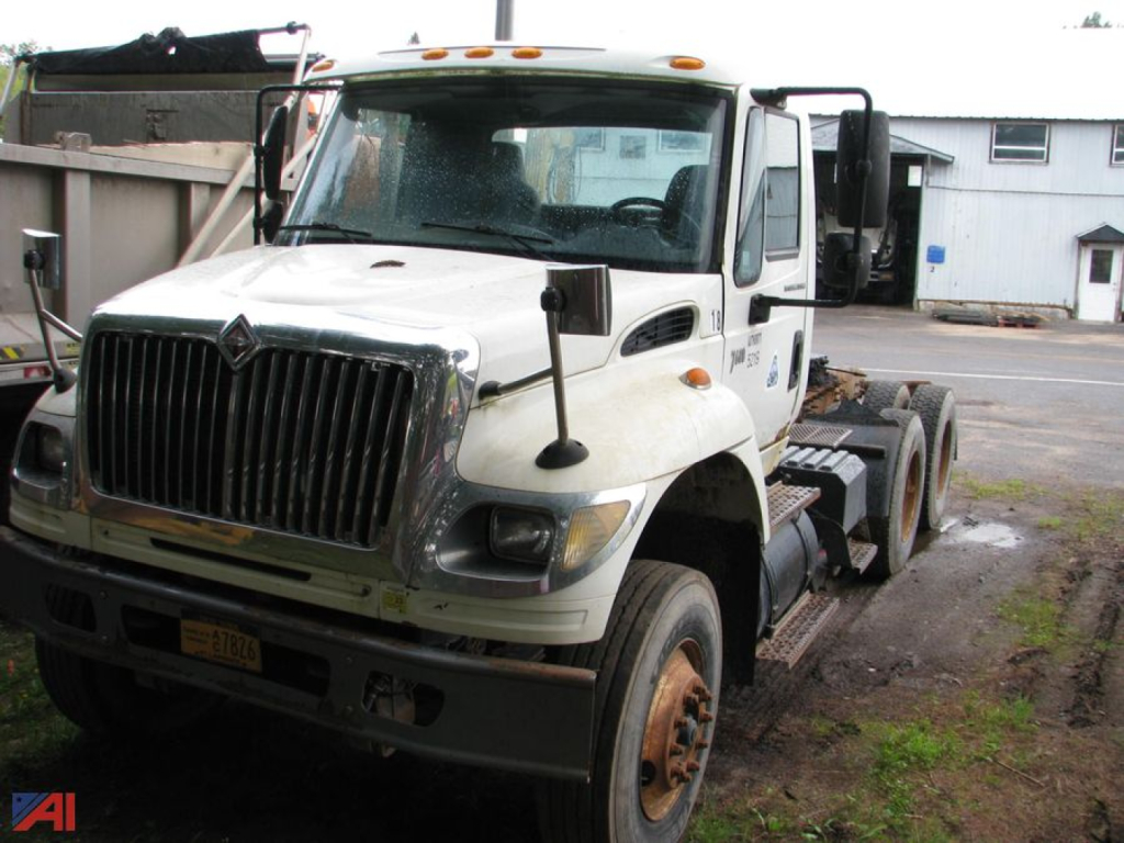 International SF547 WorkStar 7600 tractor-trailer cab showing front grille, dual mirrors, and 6x4 rear axle configuration.