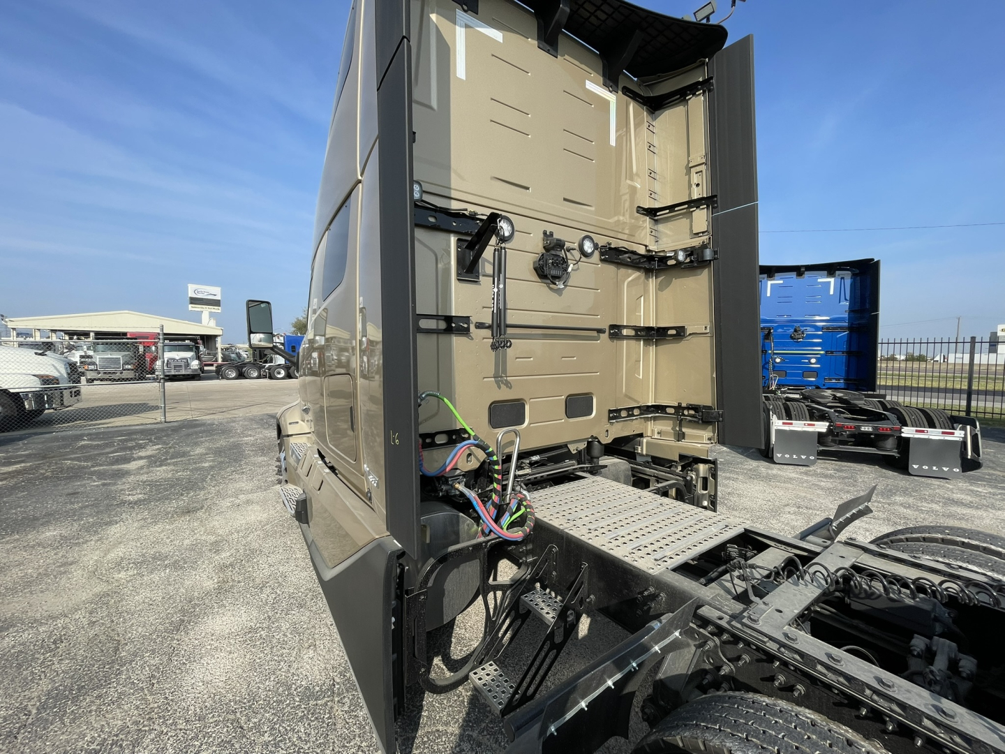 Volvo VNL64T860 truck cab rear view showing access doors and wiring harness, with trailer hitch area and chassis.