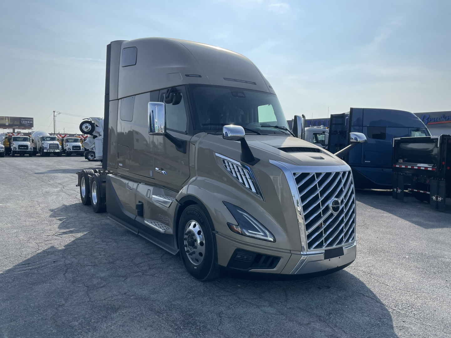 Volvo VNL64T860 semi truck in a dealership lot, showing the chrome grille, aerodynamic hood, and sleeper cab with dual rear axles.