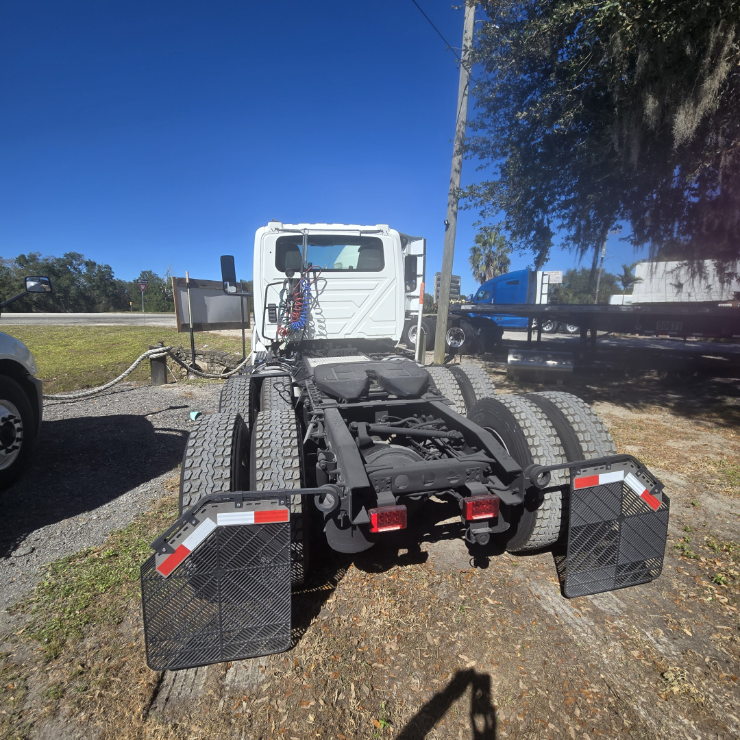 Truck chassis showing rear view of a 2018 International LT625 conventional tractor, dual rear axles, black mudflaps, and tail guards.