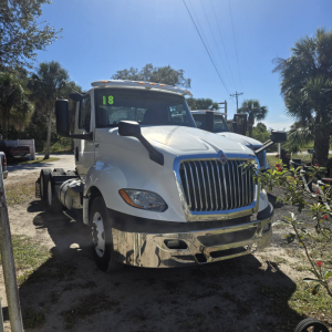 White 2018 International LT625 conventional daycab tractor front view showing chrome grille, large bumper, and green '18' sticker on windshield.