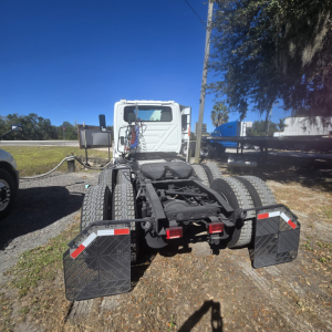 Truck chassis showing rear view of a 2018 International LT625 conventional tractor, dual rear axles, black mudflaps, and tail guards.