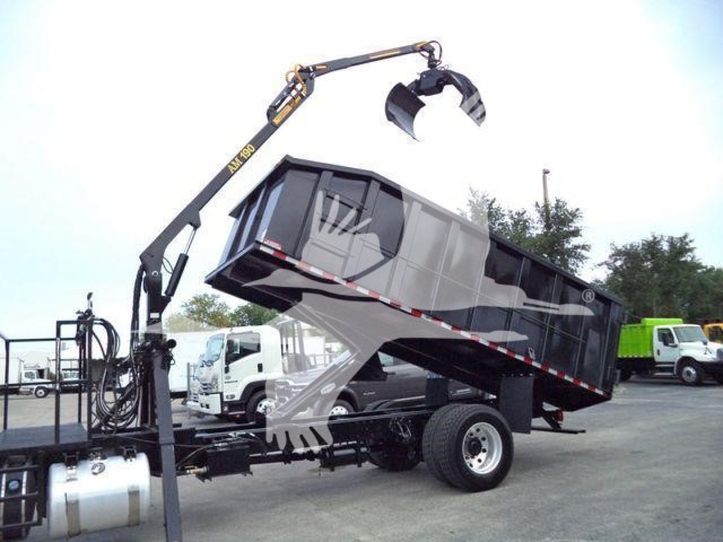 Peterbilt 337 grapple truck with dump bed raised, hydraulic crane and claw attachment visible, used stock photo.