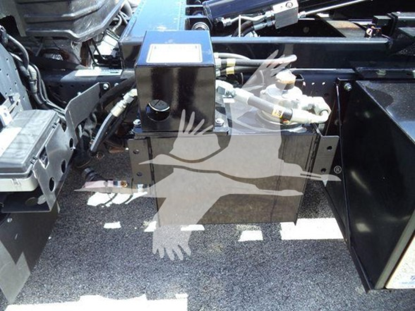 Isuzu NPR-HD truck chassis with hooklift components and hydraulic system visible in engine bay area.