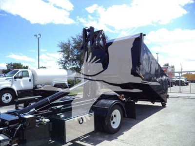 Isuzu NPR-HD truck with hooklift bed side view showing large black and white dump container and chassis.