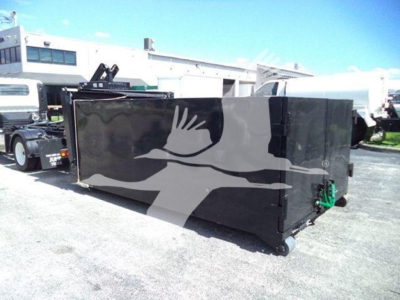Isuzu NPR HD hooklift truck chassis container in a lot showing black rectangular cargo container with green hitch components.