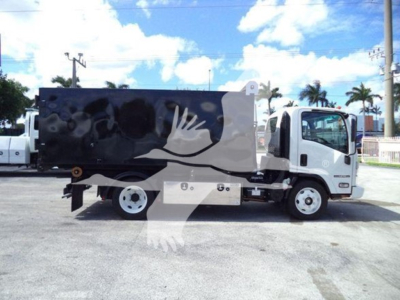 Isuzu NPR-HD truck with a large black enclosed hopper and crane hooklift in a lot.