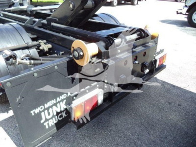 Isuzu NPRHD hooklift truck rear with wheel hubs and mechanical arms visible, showing bumper, tail lights, and platform label 'TWO MEN AND A JUNK TRUCK' near the hitch.