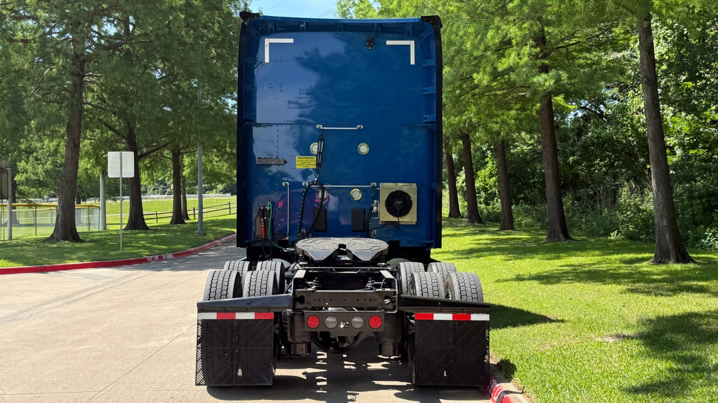 Kenworth T680 truck rear view showing fifth wheel, dual rear axles, and exhaust components with equipment connections visible.