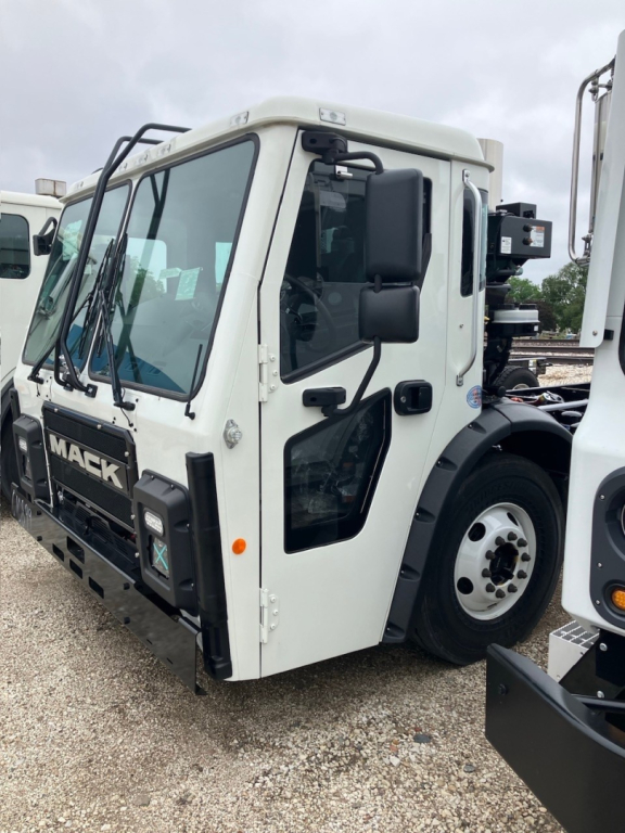 Mack LR64 cab and chassis truck front-left view showing squared cab, windshield wipers, and side mirror.