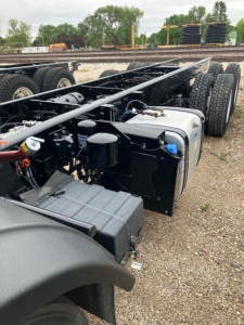 Truck chassis with fuel tanks and air lines in view for a 2025 Mack LR64 cab and chassis showing dual fuel tanks and chassis frame