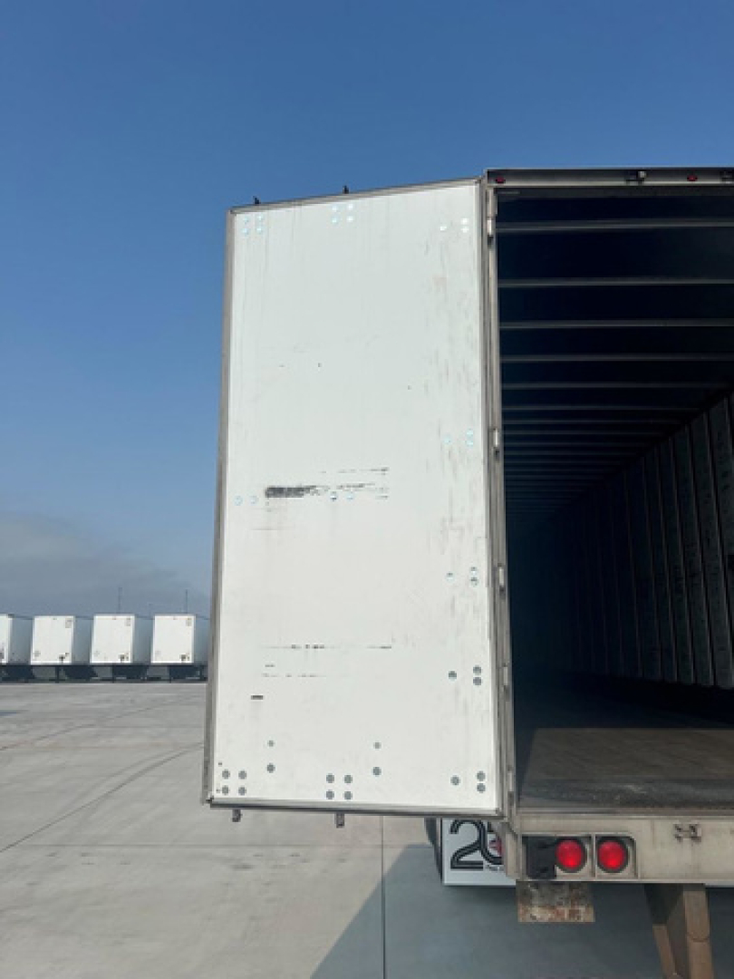 Utility van trailer rear showing open cargo area and back doors with loading platform and taillights.