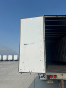 Utility van trailer rear showing open cargo area and back doors with loading platform and taillights.