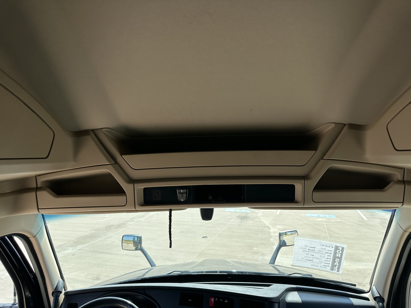 Kenworth T680 cab interior front view with overhead console and windshield, showing dash and mirrors.