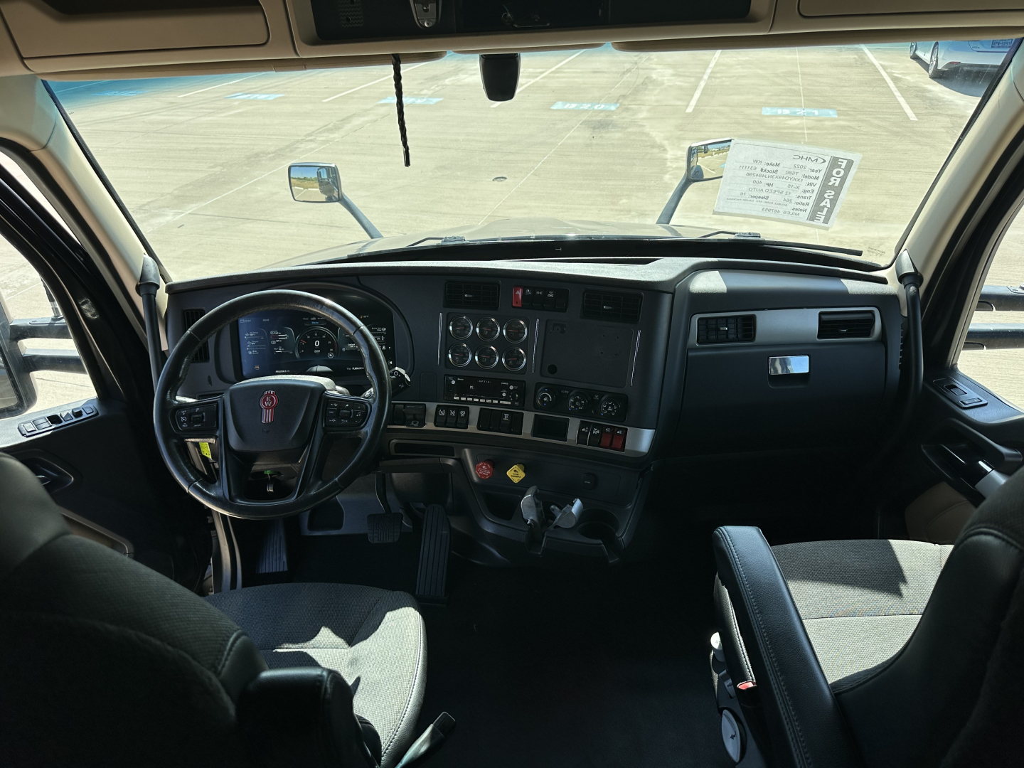 Kenworth T680 truck interior cabin view showing steering wheel, dashboard, and controls.